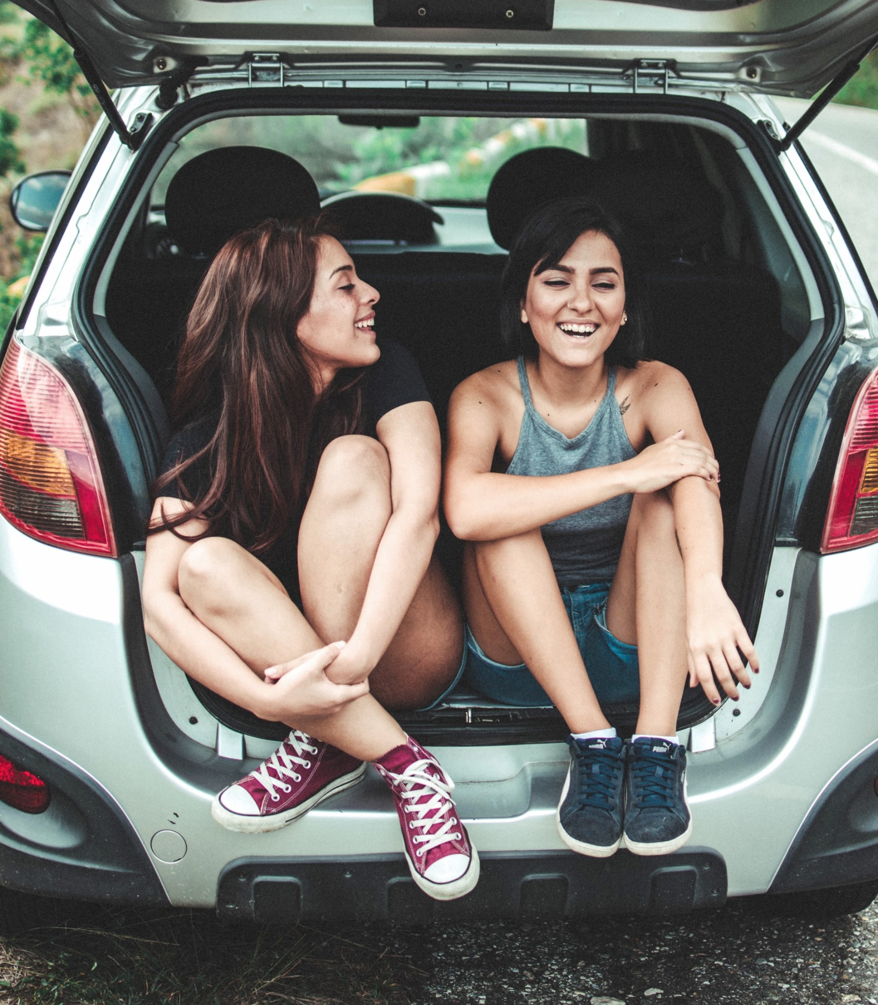 Two Women Sitting in the back of a car talking